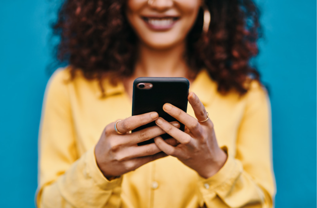 A woman holding a mobile device in her hands.